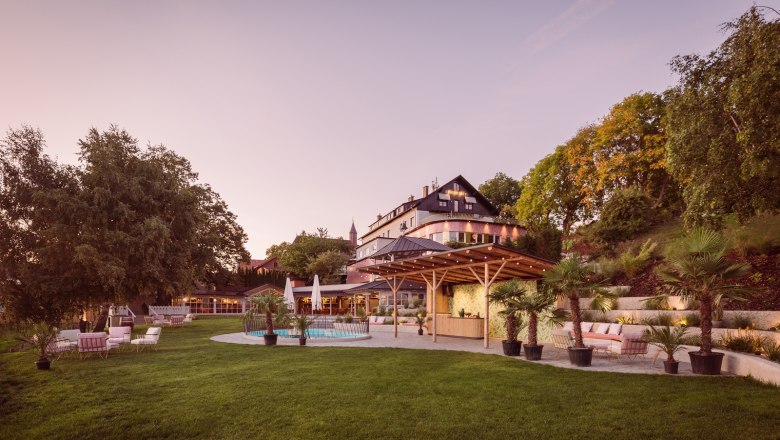 Large house with garden and pool at sunset.