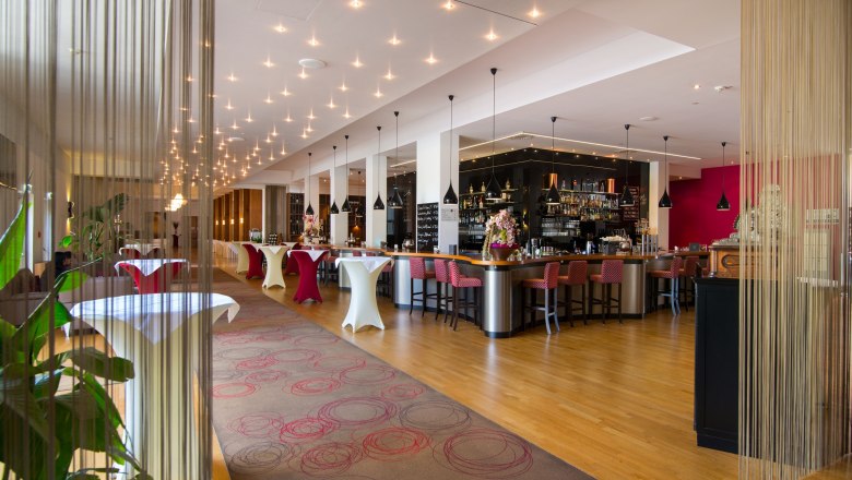 Elegant hotel bar with modern furniture and stylish lighting.