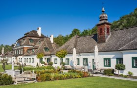 Schloss Luberegg with its well-tended garden and blue sky.