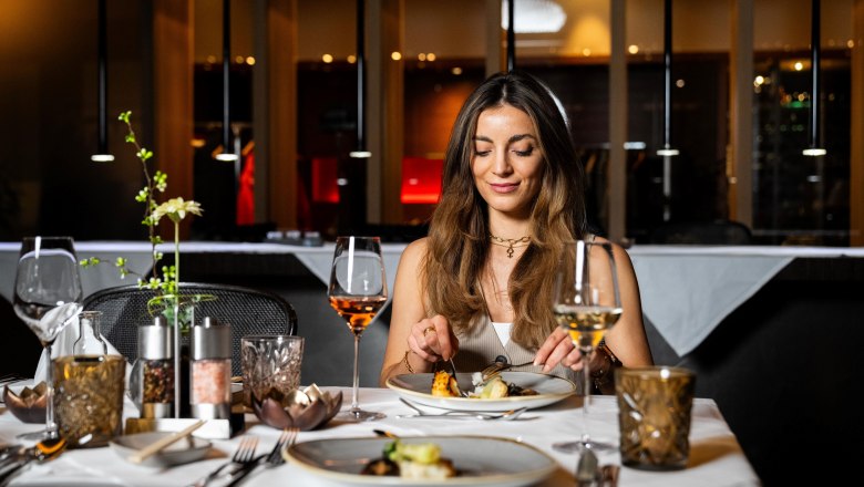 Woman enjoys an elegant dinner in a stylish restaurant.