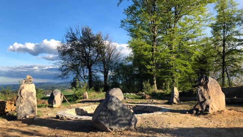 Stone circle in a forest clearing at sunset.