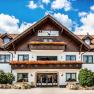 A traditional hotel with wooden balconies and flower boxes against a blue sky.