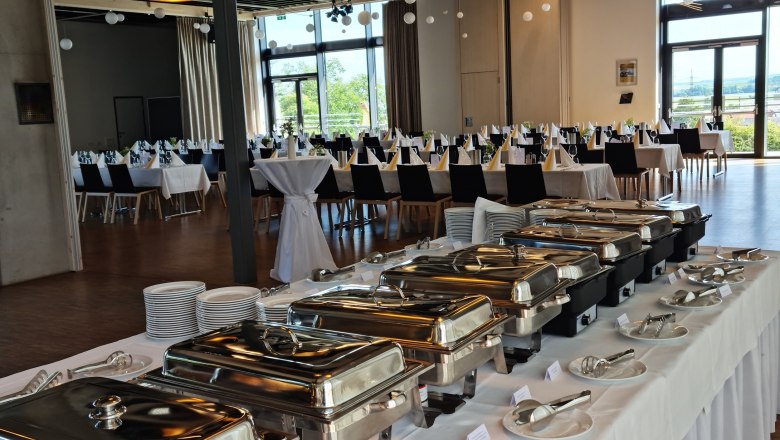 A festively decorated room with a buffet and laid tables.