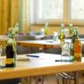 A seminar room with tables on which drinks and glasses are placed.