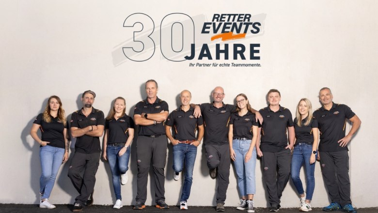 Group of ten people in black clothing in front of a wall with the RETTER EVENTS logo and the text '30 years'.
