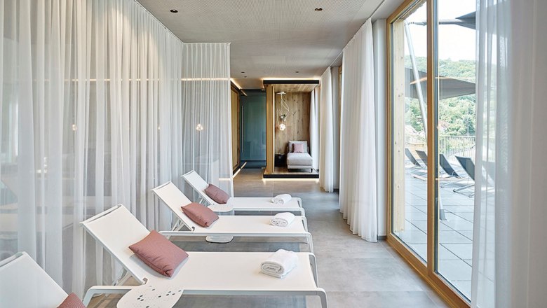 Modern spa area with loungers and large windows.
