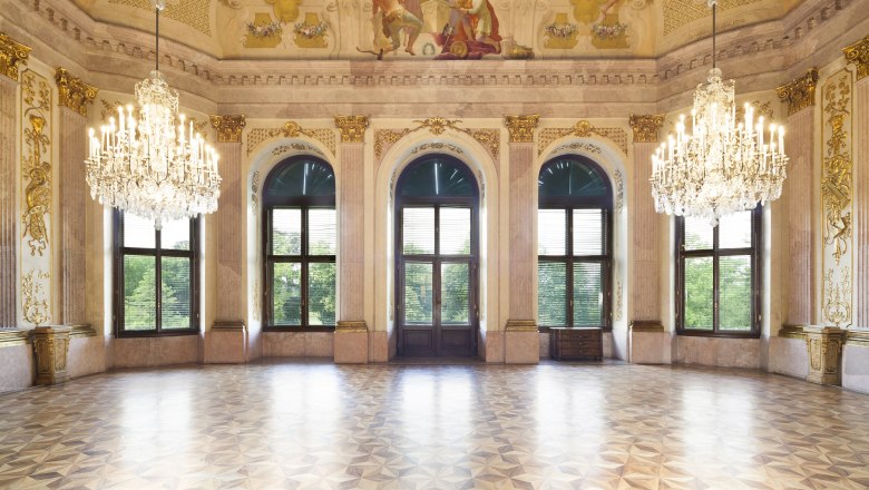Magnificent ballroom with chandeliers and murals in Eckartsau Castle.