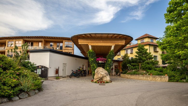 Entrance to the Naturhotel Molzbachhof with wood paneling and plants.