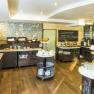 A breakfast buffet with a variety of food and drinks in a bright room.