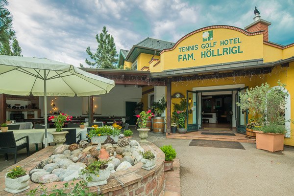 Entrance to the Tennis Golf Hotel H&ouml;llrigl with terrace and plants.