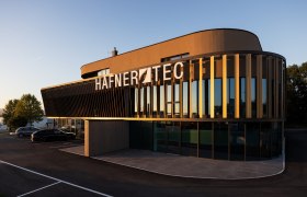 Modern building with the inscription 'HAFNER TEC' at sunset.