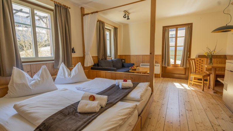 Comfortable room with double bed, sofa, dining table and large windows in the K&ouml;nigsleitn theater and vacation village.