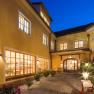 Inner courtyard of the Hotel Zum Schwarzen B&auml;ren with illuminated windows and plants at night.