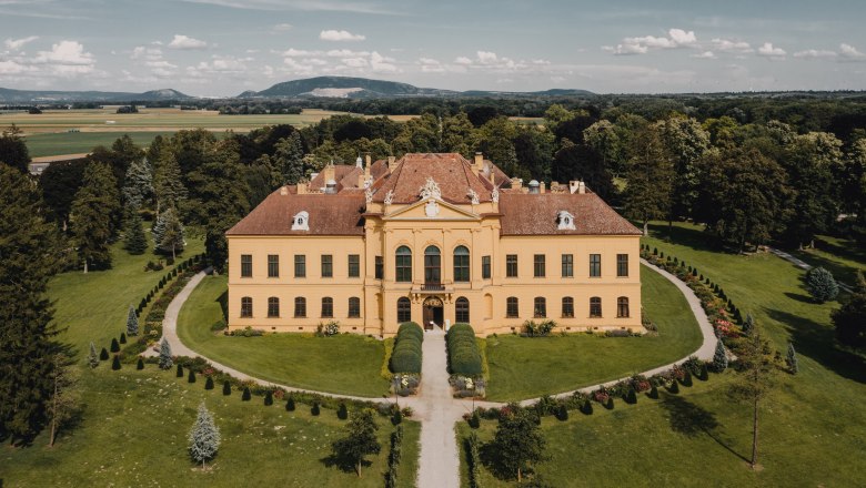 Aerial view of Eckartsau Castle surrounded by green countryside.