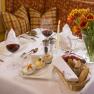 An elegantly laid table with wine glasses, candles, tulips and bread.