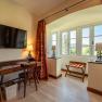 Hotel room with desk, chair, TV and window with a view.