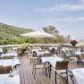 Restaurant terrace with covered tables and views of the vineyards.