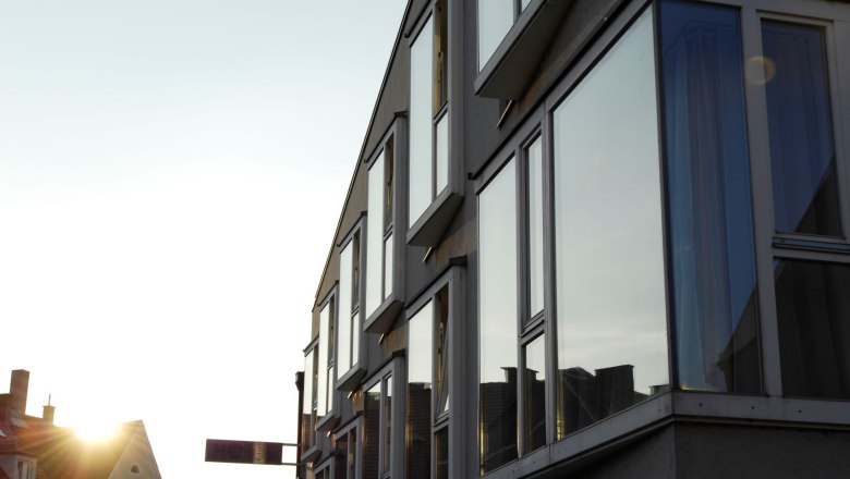 Modern building fa&ccedil;ade with large windows in the sunset.