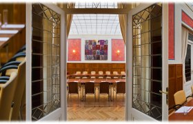 Conference room in the Hotel Herzoghof with long tables, chairs and presentation equipment.
