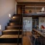 Interior view of a modern hotel room with stairs, table and chairs.