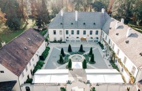 Aerial view of a historic castle with courtyard and garden.