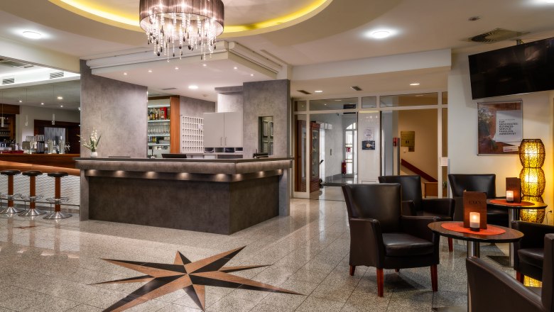 Hotel reception with bar and seating area.