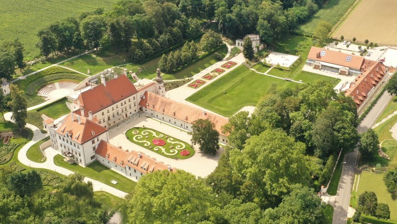 Aerial view of Schloss Thalheim with surrounding gardens and buildings.