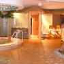 A wellness area with whirlpool, loungers and people in bathrobes.