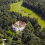 Aerial view of Ernegg Castle surrounded by woods and meadows.