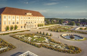 Hof Palace with its magnificent baroque garden and fountain in sunny weather.