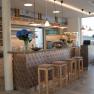 Modern bar with wooden decor, bar stools and flowers.