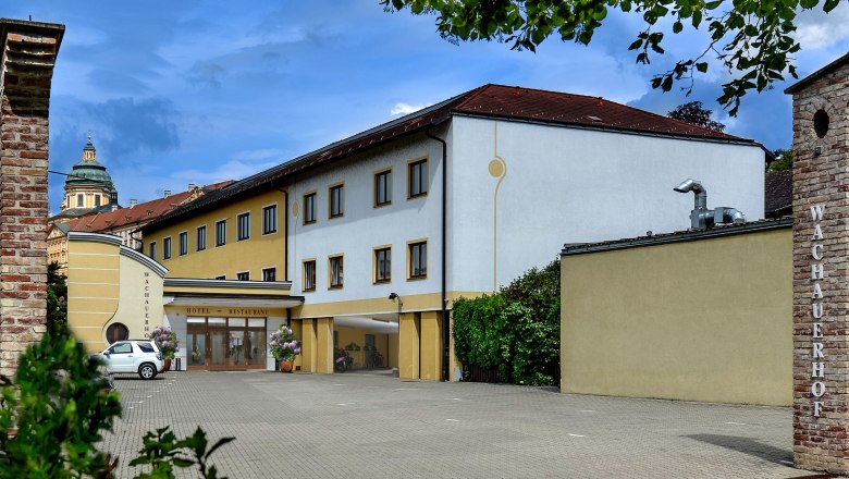 Exterior view of the Wachauerhof in Melk with parking lot and building facade.